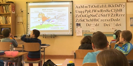 Powiększ grafikę: Uczniowie w sali lekcyjnej oglądają prezentacje na temat autyzmu
