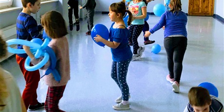 Powiększ grafikę: Uczniowie bawią się niebieskimi balonami 